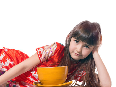 Portrait of caucasian little girl in vietnamese national costume keep wooden bowl and plate isolated on whiteの写真素材
