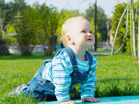 Portrait of nice caucasian baby boy playing at summer park outdoorsの写真素材