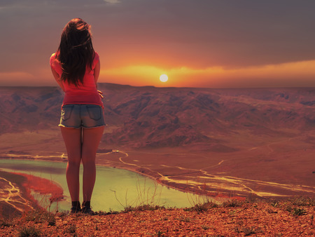 Portrait of young caucasian beautiful sport  women at sunset background of river in blue pantsの写真素材