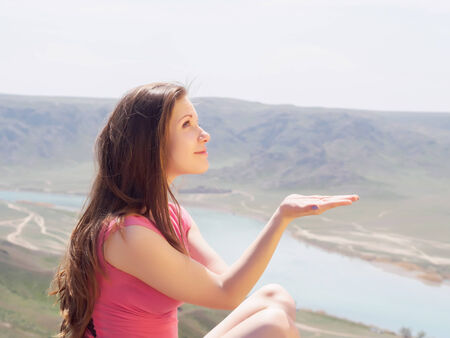Portrait of young caucasian beautiful sport  women holds hand in summer nature on the background of riverの写真素材