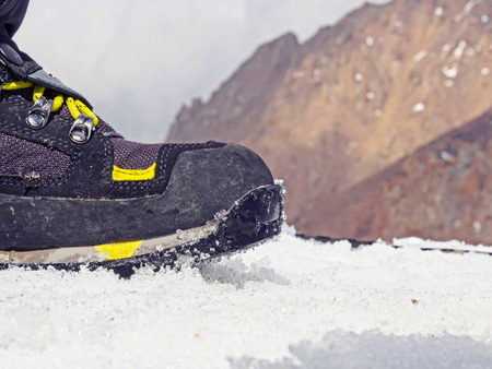 Boot of climber sportsmen hiking to the mountain peak