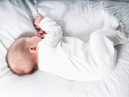 Caucasian newborn baby toddler boy sleeping in his bedの写真素材