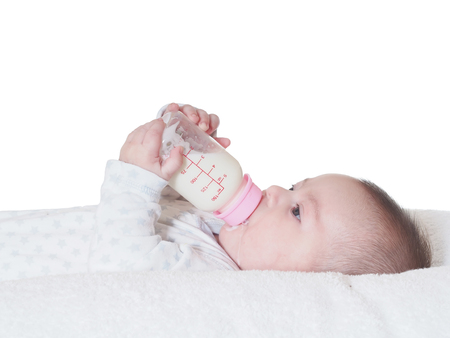 Caucasian baby boy four months drinking milk from the bottle isolatedの写真素材