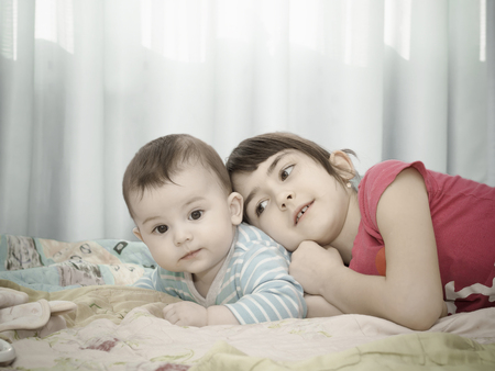 Portrait of caucasian sister and brother children playing at homeの写真素材