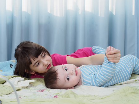Portrait of caucasian sister and brother children playing at homeの写真素材