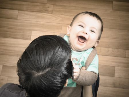 Caucasian mother and her baby boy playing together at home