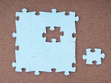 Concept of blue puzzle pieces on the brown backgroundの写真素材
