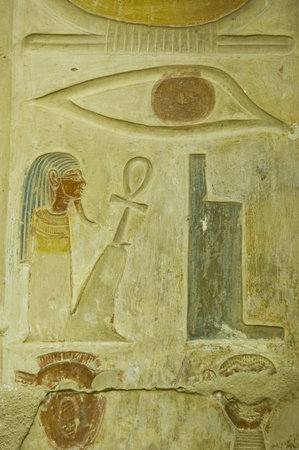 Ancient Egyptian hieroglyphs carved on a wall of Abydos Temple near el Balyana, Egypt   An eye, throne, squatting pharaoh and two heads    Ancient carving, on public display over 1000 years のeditorial素材