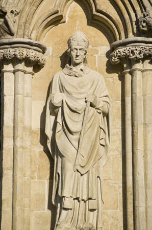 Stone statue of Bishop Brithwold on the West Front of Salisbury Cathedral, Wiltshire  Sculpted in 1868 by James Redfern and on public display since の写真素材