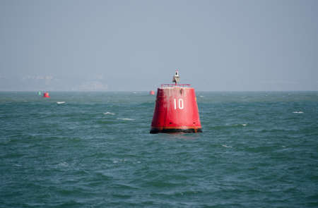 A large, red marker buoy, labelled 10 at the entrance to Poole Harbour, Dorset の写真素材