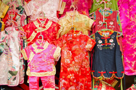 BANGKOK, THAILAND - OCTOBER 27 2013  Colourful dresses and pyjama suits for small children made in traditional Chinese styles on display at a market stall in the Chinatown district of Bangkok のeditorial素材