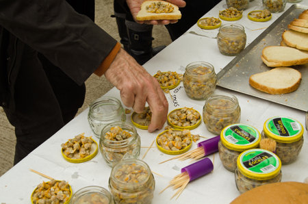LAUGHARNE, CARMARTHENSHIRE - MAY 5 2014  Audience members enjoy cockles on bread at the end of the National Theatre Wales play Llareggub - inspired by the work of poet Dylan Thomas のeditorial素材