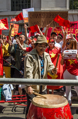 LONDON, ENGLAND - MAY 18, 2014  Drummer beating a rhythm for Vietnamese protesters to chant with outside the Chinese Embassy in London   The demonstration is against china moving an oil rig into dispute waters in the South China Sea のeditorial素材