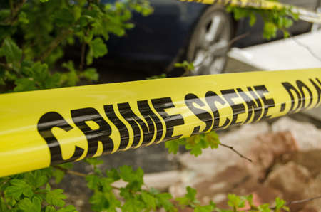 Yellow tape barrier surrounding a crime scene under investigation by the police 