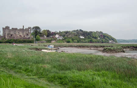 View across the River Taff estuary at Laugharne with marshland and the town s famous Norman Castle, Caramarthenshire, South Wales の写真素材