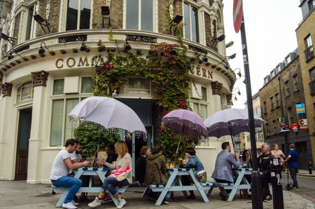 LONDON, UNITED KINGDOM - AUGUST 30, 2014:  Drinkers enjoying the open air tables outside the fashionable Commercial Tavern in the hip district of Shoreditch in London\\\\のeditorial素材