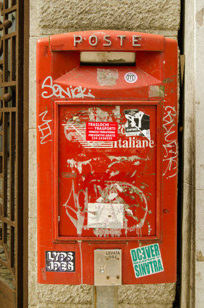 VENICE ITALY  MAY 24 2015:  An Italian post box covered in stickers and graffiti on a wall in Lido Venice.のeditorial素材