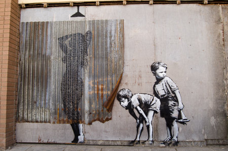 WESTON-SUPER-MARE, UK - AUGUST 26, 2015:  Banksy graffiti style picture of young boys peeping at a woman taking a shower.  Painted on the wall of the disused Tropicana swimming pool at the traditional seaside resort of Weston-Super-Mare in Somerset.  On pのeditorial素材