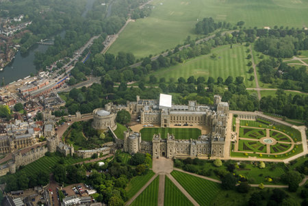 View from a plane of the historic Windsor Castle, home of Queen Elizabeth II in Royal Berkshire.  The River Thames passes to the left hand side and castle grounds stretch to the edge of the image.  Cloudy Summer morning in June 2016.のeditorial素材