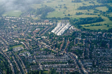 Aerial view of Teddington, Middlesex in the London Borough of Richmond Upon Thames in West London.  The long white building is the National Physical Laboratory and beyond is Bushy Park.  Sunny summer morning.の写真素材