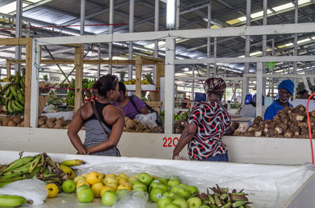SCARBOROUGH, TRINIDAD AND TOBAGO - JANUARY 11, 2019:  Shoppers perusing the fresh produce on sale at...