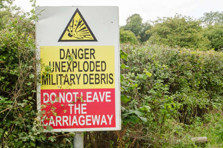 Sign beside a road on Salisbury Plain warning of unexploded ordnance.  The area is usually closed to...