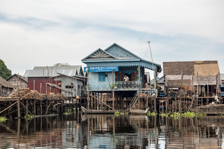 Kampong Phluk, Cambodia - December 4, 2011:  A man relaxing on the terrace of the Cambodian People's Party offices built on stilts in the floating village of Kampong Phluk on the Tonle Sap lake in the Siem Reap district of the country.のeditorial素材