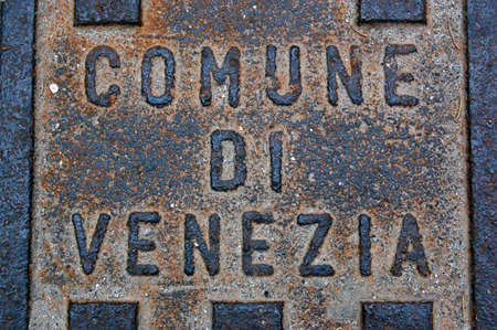 A rusty cast iron manhole cover over a drain in Venice, Italy.の写真素材
