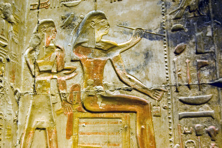 A decorated hieroglyphic carving of an ancient egyptian artist painting on a wall. Inner wall at the...