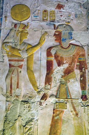 Ancient egyptian hieroglyphic carving of the goddess Hathor with an ankh before the Pharoah Seti I. Coloured carving on a wall of the Temple of Abydos, Egypt.の写真素材