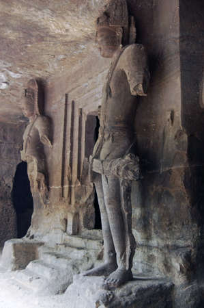 Two giant statues of the hindu god Shiva standing either side of the entrance to the altar in one of the cave temples on Elephanta Island off the coast of Mumbai, formerly Bombay, India.の写真素材