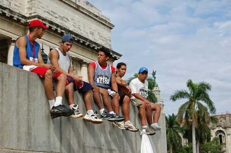 Havana, Cuba - November 20, 2005: Competitors in the Havana Marathon relaxing on the steps of the magnificent Capitolio building after running through the city in tropical heat.のeditorial素材