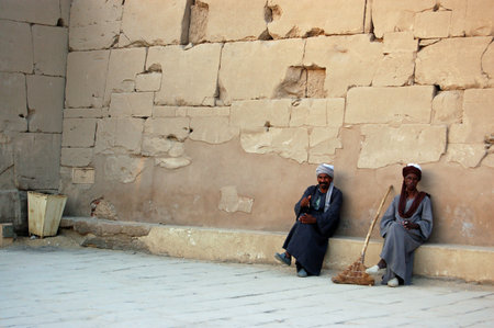 Luxor, Egypt - January 5, 2006: Two custodians take a rest in the evening heat after cleaning the magnificent Ancient Egyptian Temple of Karnak.のeditorial素材