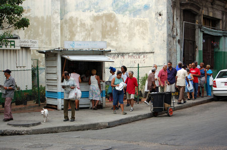 Havana, Cuba - November 12, 2006: A queue of Havana residents waiting to buy a newspaper from a wooden stall on a street corner in Old Havana.のeditorial素材