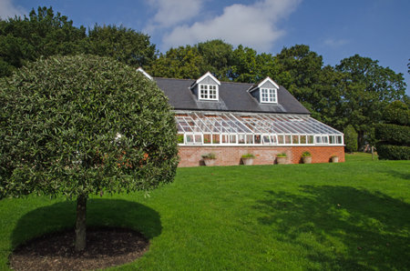 Hampshire, UK - September 15, 2021:  Exterior of the historic conservatory used for growing deliate plants at the Honesty Kitchen Cookery School in North Sydmonton, Hampshire on a sunny summer afternoon.のeditorial素材