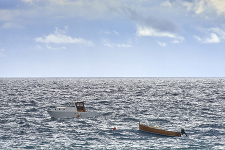 moored boats and rough seaの写真素材