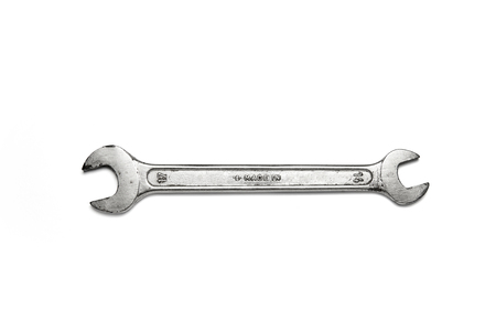 chromed mechanical key used on a white backgroundの写真素材