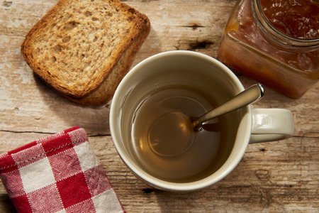 cup of tea with spoon jam and breadの写真素材