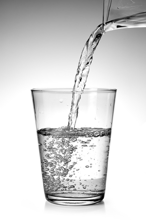 pouring fresh water into a glassの写真素材