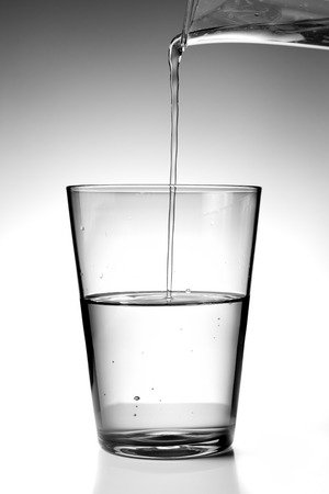 pouring fresh water into a glassの写真素材