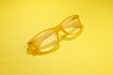 yellow plastic glasses on a yellow backgroundの写真素材