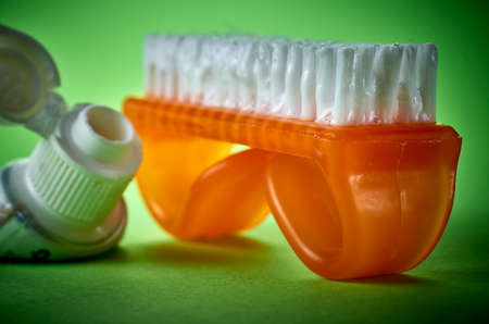 curious nail brush used as a toothbrush on a green background