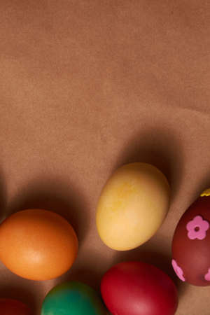 Colorful Easter eggs on brown background close-up