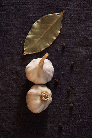 Garlic, onion, bay leaf, black pepper on textile background. Garlics. sliced garlic, garlic clove garlic bulbの写真素材