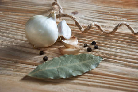 onion, garlic, black pepper and bay leaf on a black backgroundの写真素材