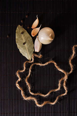 Garlic, onion, bay leaf, black pepper on black table. Garlics. sliced garlic, garlic clove garlic...
