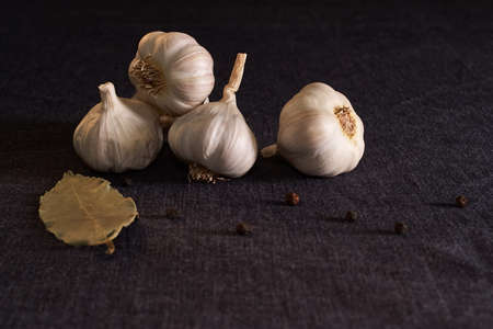 Garlic, onion, bay leaf, black pepper on textile background. Garlics. sliced garlic, garlic clove...