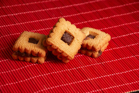 Chocolate cookies on gray plate on red tableの写真素材