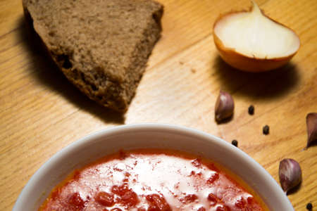 Homemade red beetroot soup on background. Raw vegetables and rye bread. Traditional Ukrainian borsch