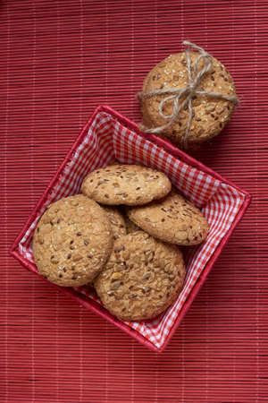 Cookies with sesame and sunflower seeds on wooden table and burlap background. Healthy eating